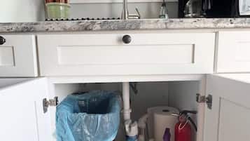 A kitchen with a window above the sink, a coffee maker, and a fire extinguisher.
