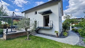 A modern two-story house with a balcony, a small garden, and a clear sky. - Maison au Calme et en Ville (Annecy)