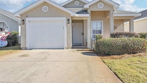 A two-story house with a white garage door, a covered entryway, and a mailbox. - SEASHORE · *Summer’s Special | King Bed| Cvrd Back Porch* (Panama City Beach)