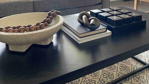 Un salon moderne avec un canapé gris, une table basse en bois et un lampadaire.