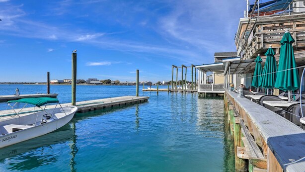 A marina with a docked boat, wooden pier, and a building with outdoor seating and umbrellas. - The Beaufort Flat Near Downtown & Waterfront! (Beaufort)