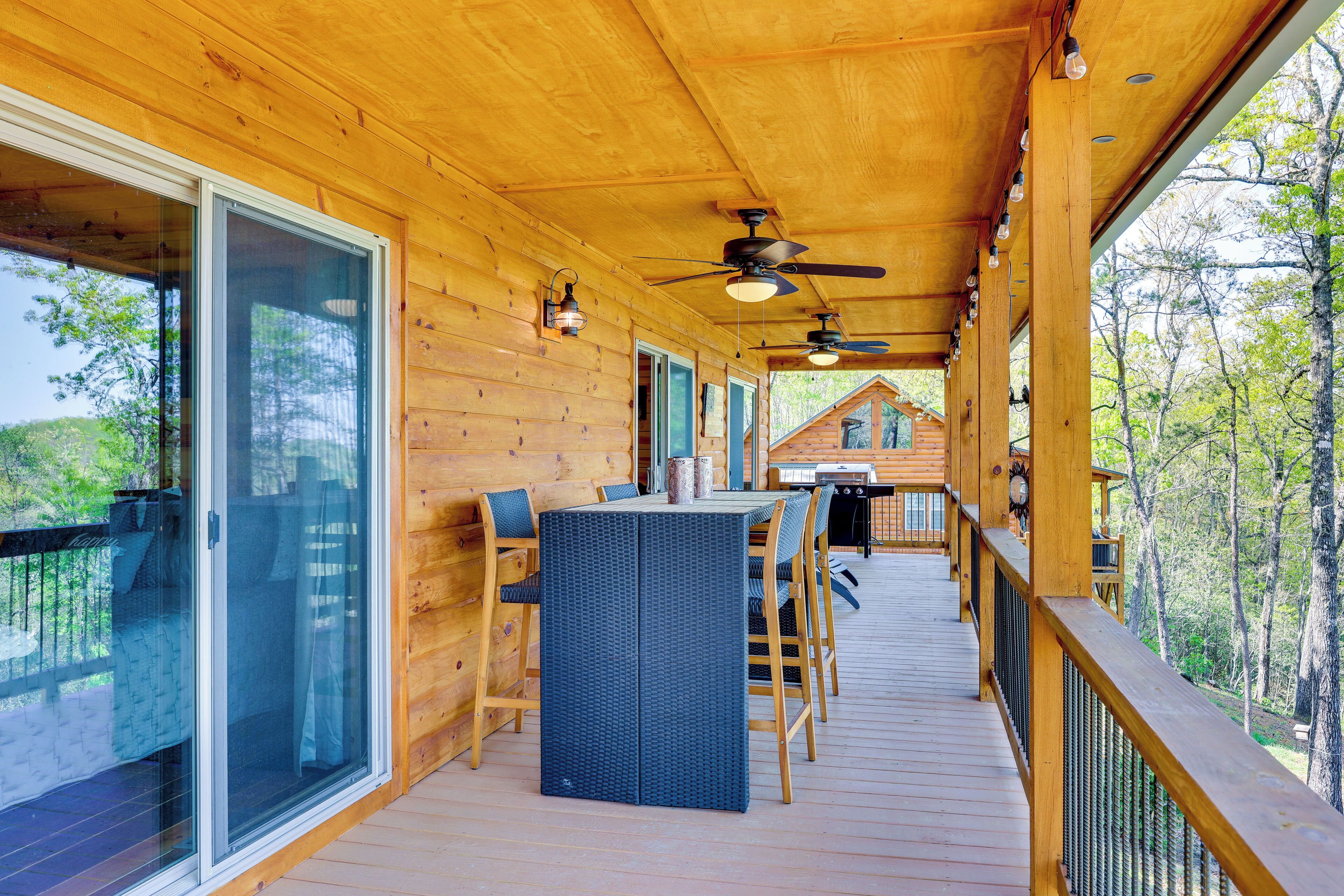 A wooden deck with a glass door, a table with chairs, and a ceiling fan.