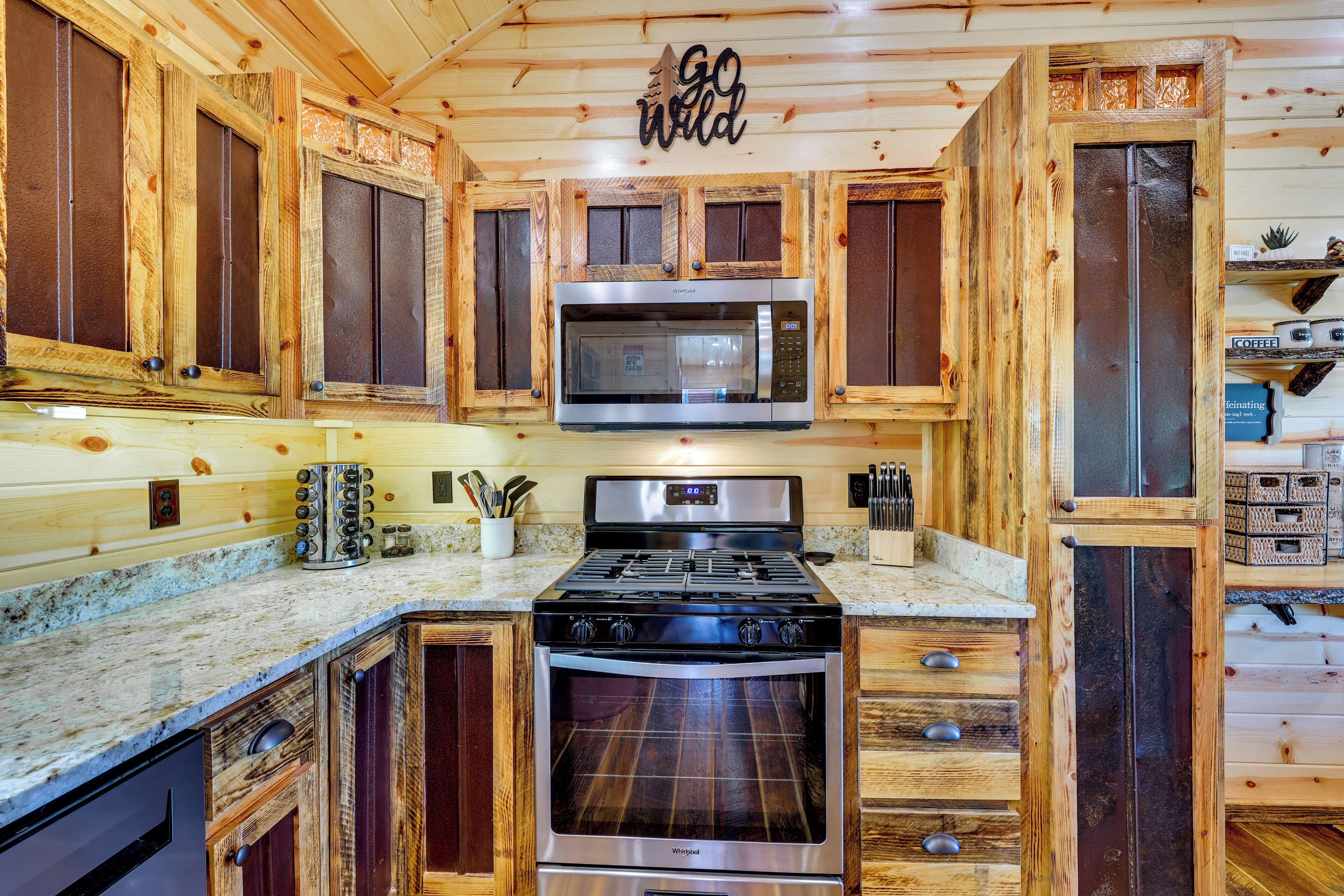 Une cuisine avec des meubles en bois, un four à micro-ondes, une cuisinière et un four encastré.
