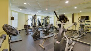 Ein Fitnessstudio mit unterschiedlichen Trainingsgeräten, darunter Laufbänder, Ergometer und Kraftgeräte.