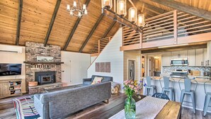 Un espacio habitable amplio con chimenea, un sofá y una mesa de comedor con sillas.