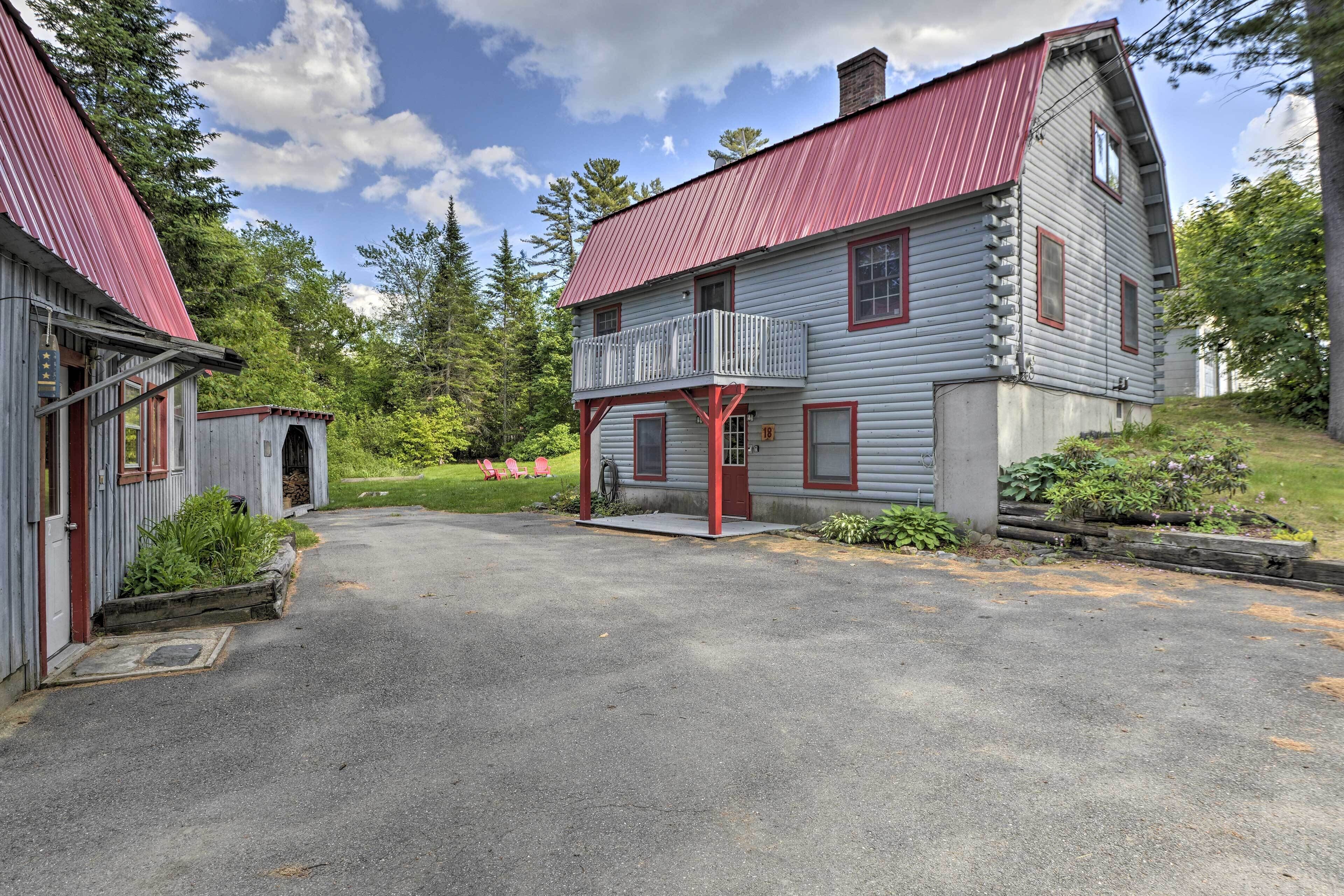 A two-story house with a red roof and a balcony.