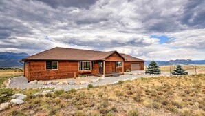 A wooden cabin with a sloped roof, large windows, and a porch. - Buena Vista Retreat: 7 Acres & Panoramic Views (Buena Vista)