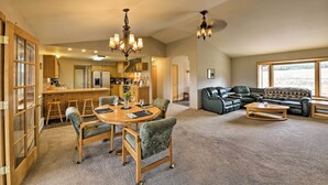 A spacious living area with a dining table, chairs, a sofa, and a coffee table. There is a kitchen in the background with a refrigerator and cabinets. - Buena Vista Retreat: 7 Acres & Panoramic Views (Buena Vista)