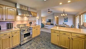 A spacious kitchen with wooden cabinets, a stainless steel stove, and a stone floor. - Buena Vista Retreat: 7 Acres & Panoramic Views (Buena Vista)