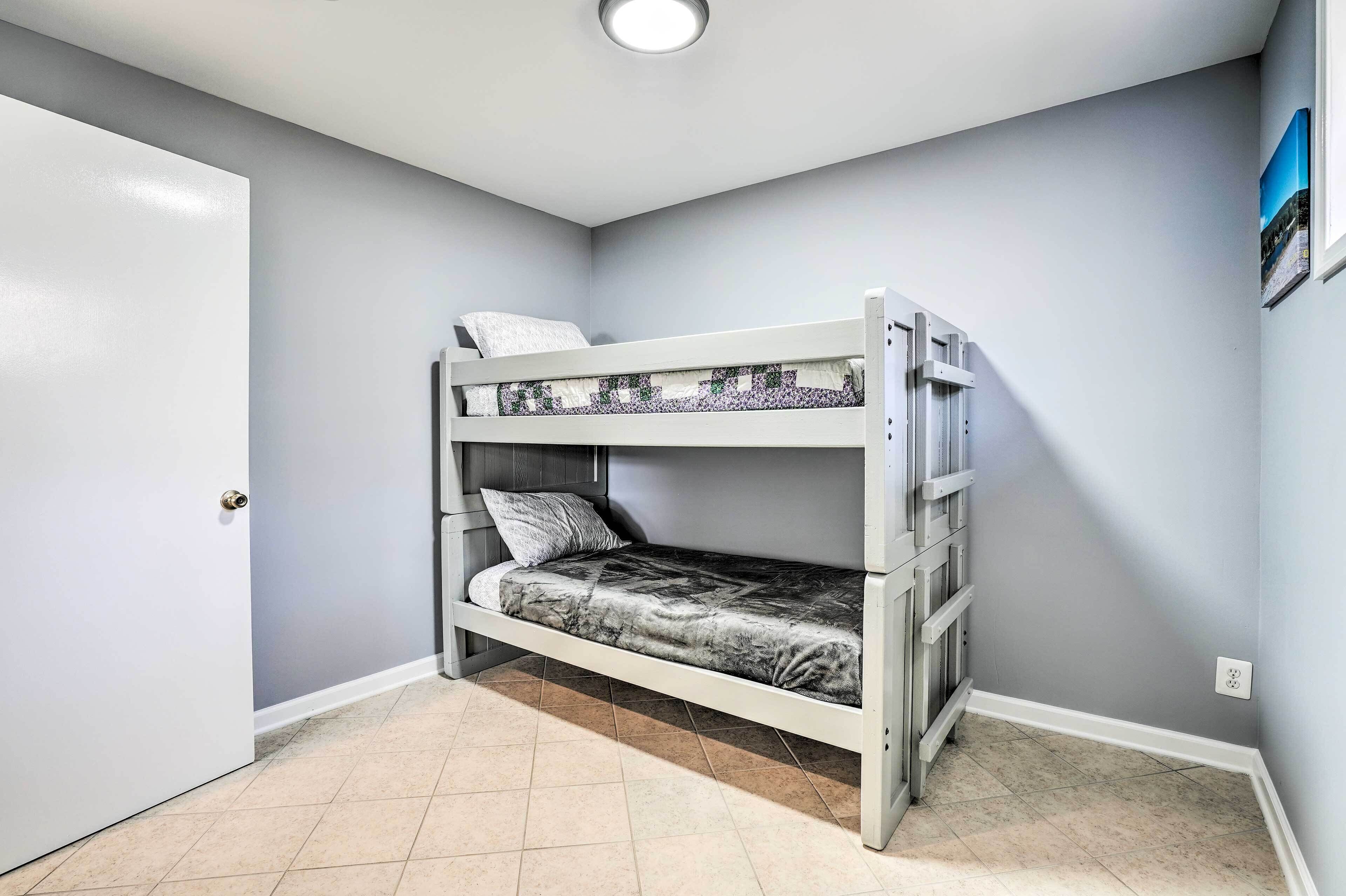 A bunk bed in a room with light gray walls and a white door.