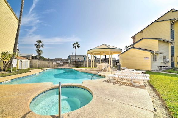 A swimming pool with lounge chairs and a gazebo.