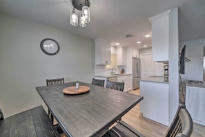 A modern kitchen with white cabinets, a built-in oven, and a stainless steel refrigerator.