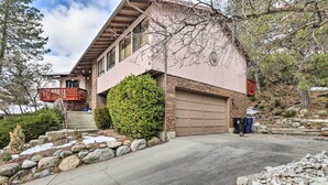 Ein zweistöckiges Haus mit Garage, Balkon und gepflegtem Vorgarten mit Steinen und Sträuchern.