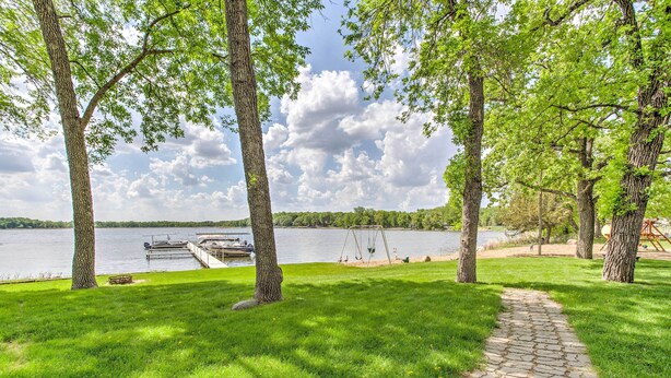 A park with a stone pathway, trees, a dock, and a lake. - Clearwater Lake Getaway w/ Shared Pool & Boat Dock (Annandale)
