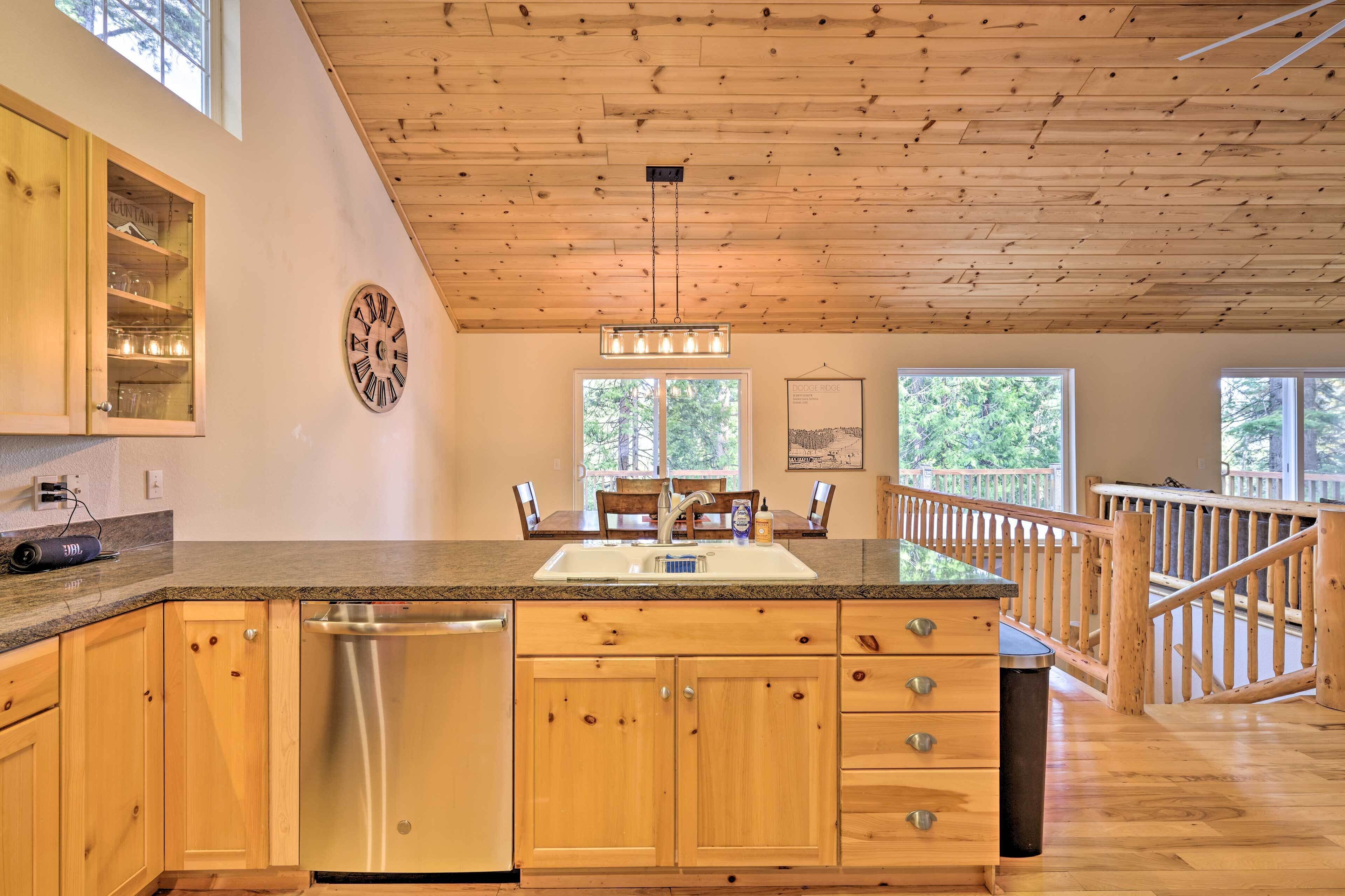 A kitchen with wooden cabinets, a stainless steel dishwasher, a granite countertop, and a wooden ceiling.