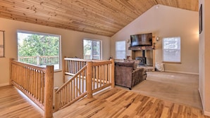 A spacious living area with a wooden ceiling, a fireplace, and a view of the outdoors. - Cold Springs Mountain Cabin: Hot Tub & Generator (Long Barn)