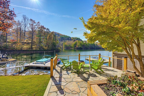 A lakeside deck with outdoor seating and a dock. - Cozy Lake Santeetlah Cottage With Dock & 3 Kayaks! (Robbinsville)