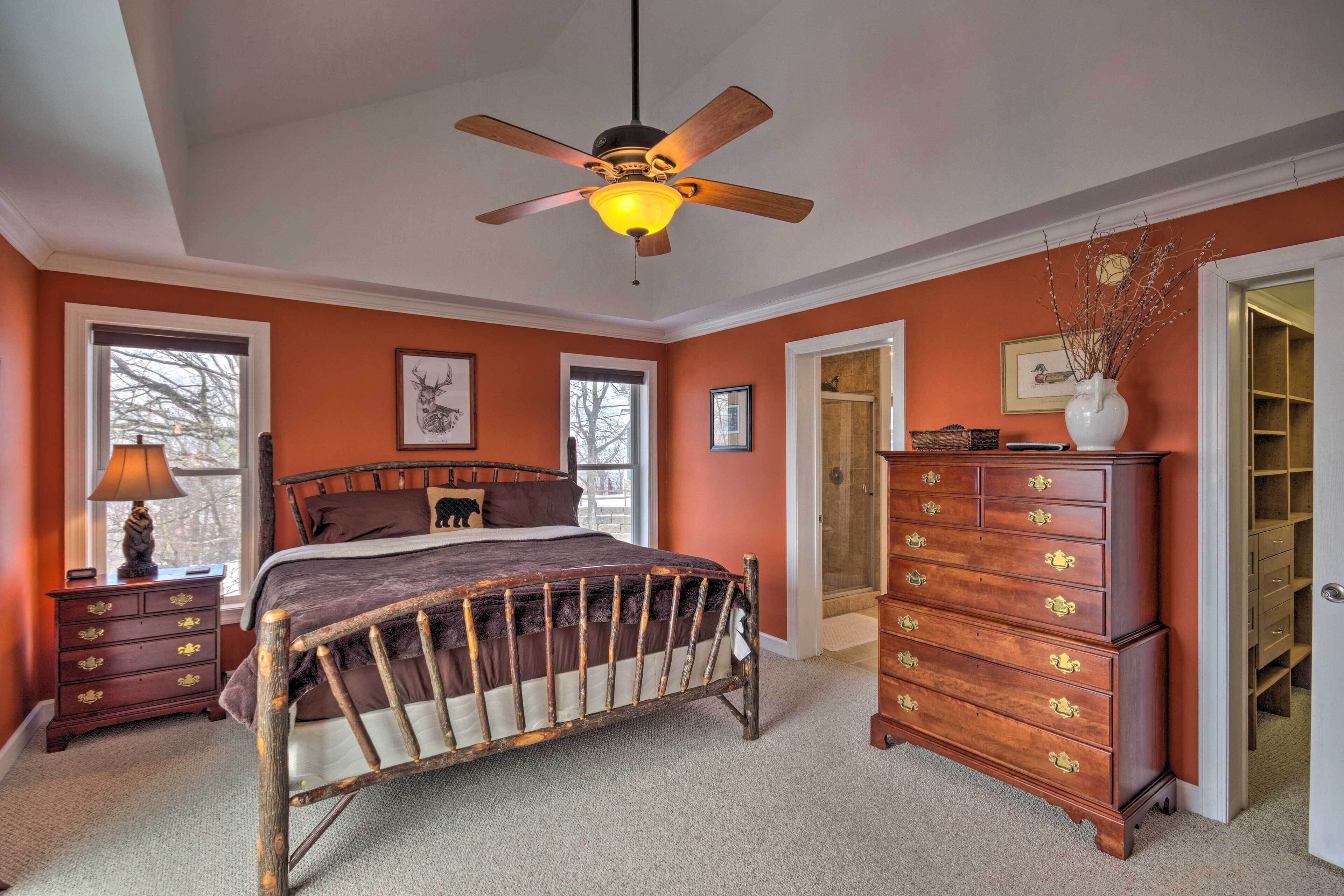 A bedroom with a wooden bed, a dresser, and a ceiling fan.