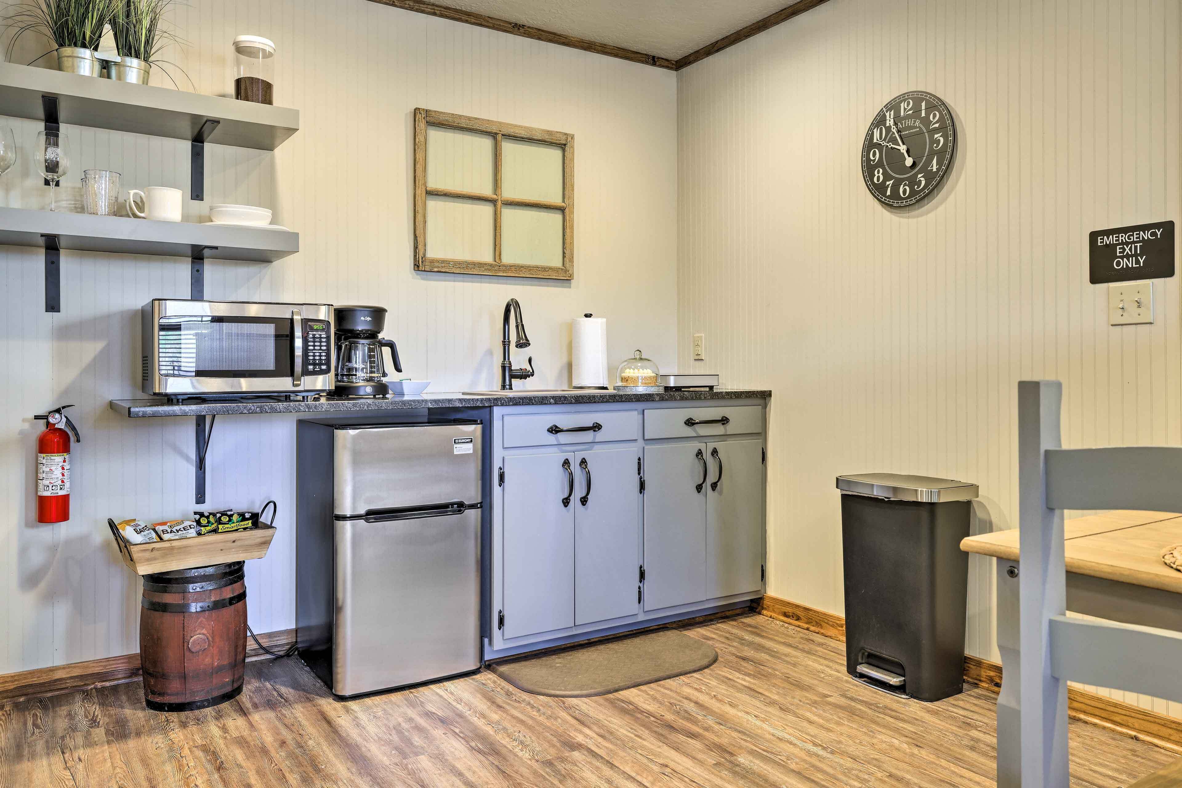 A compact kitchenette with a microwave, coffee maker, and a small refrigerator.