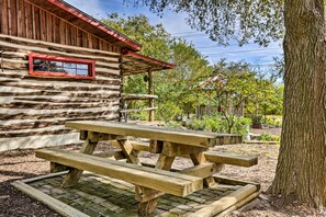 A rustic wooden cabin with a picnic table in front. - Cozy New Braunfels Family Cabin w/ Porch & Views! (New Braunfels)
