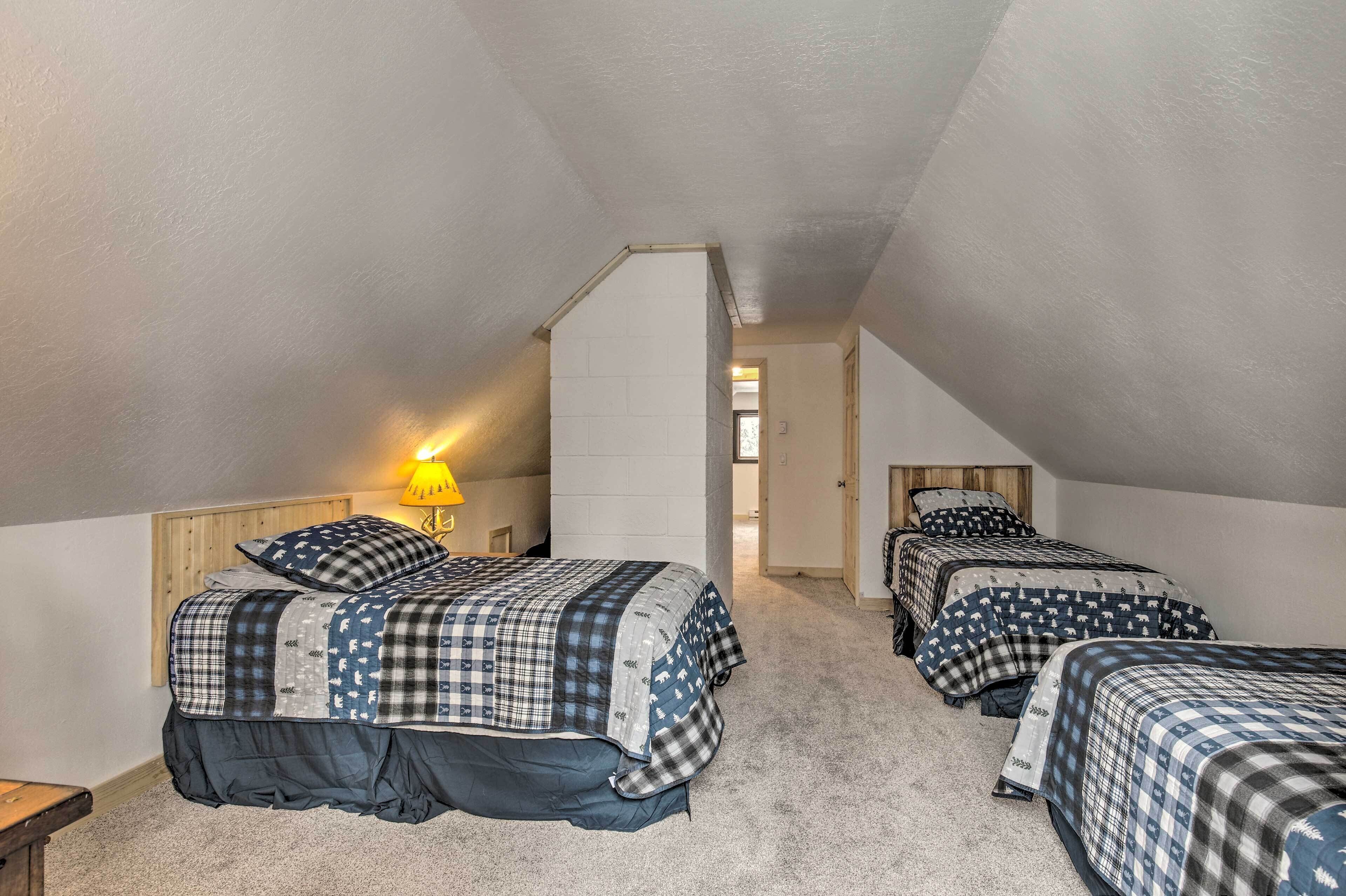 Ein Schlafzimmer mit drei Betten, einem Holzkopfteil, einer Lampe und Teppichboden.