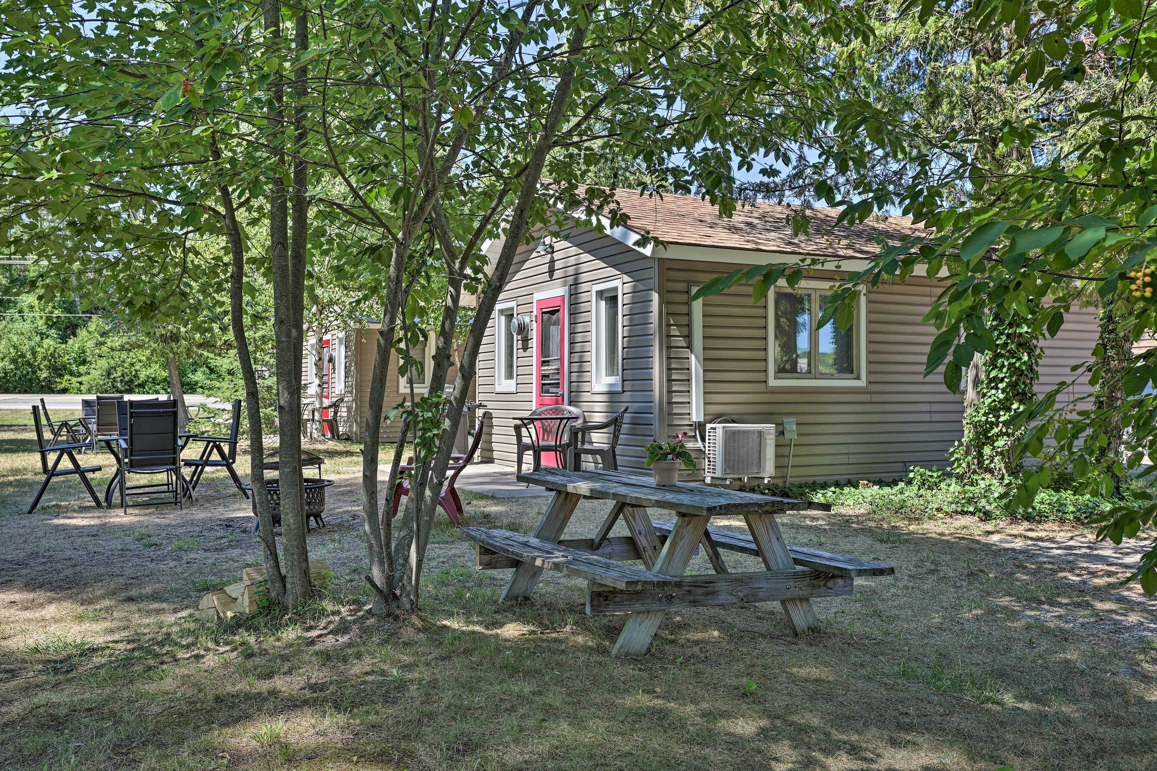 A small cabin with a picnic table and outdoor seating.