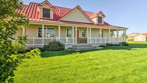 A two-story house with a red roof, a front porch with white railings, and a well-maintained lawn. - Custom Home w/ Decks in Boulder! Gateway to Parks! (Boulder)