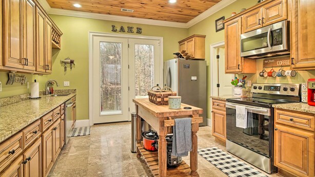 A kitchen with wooden cabinets, a granite countertop, a stove, a microwave, and a refrigerator. - Dog-friendly Family Home Steps to Norris Lake (Sharps Chapel)