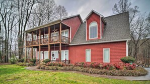 A two-story house with a balcony, surrounded by a well-maintained garden and trees. - Dog-friendly Family Home Steps to Norris Lake (Sharps Chapel)