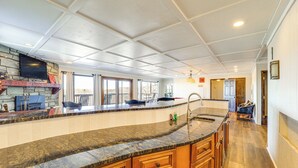 Eine geräumige Küche mit Granit-Arbeitsplatte, Holzschränken und einer Steinwandverkleidung.