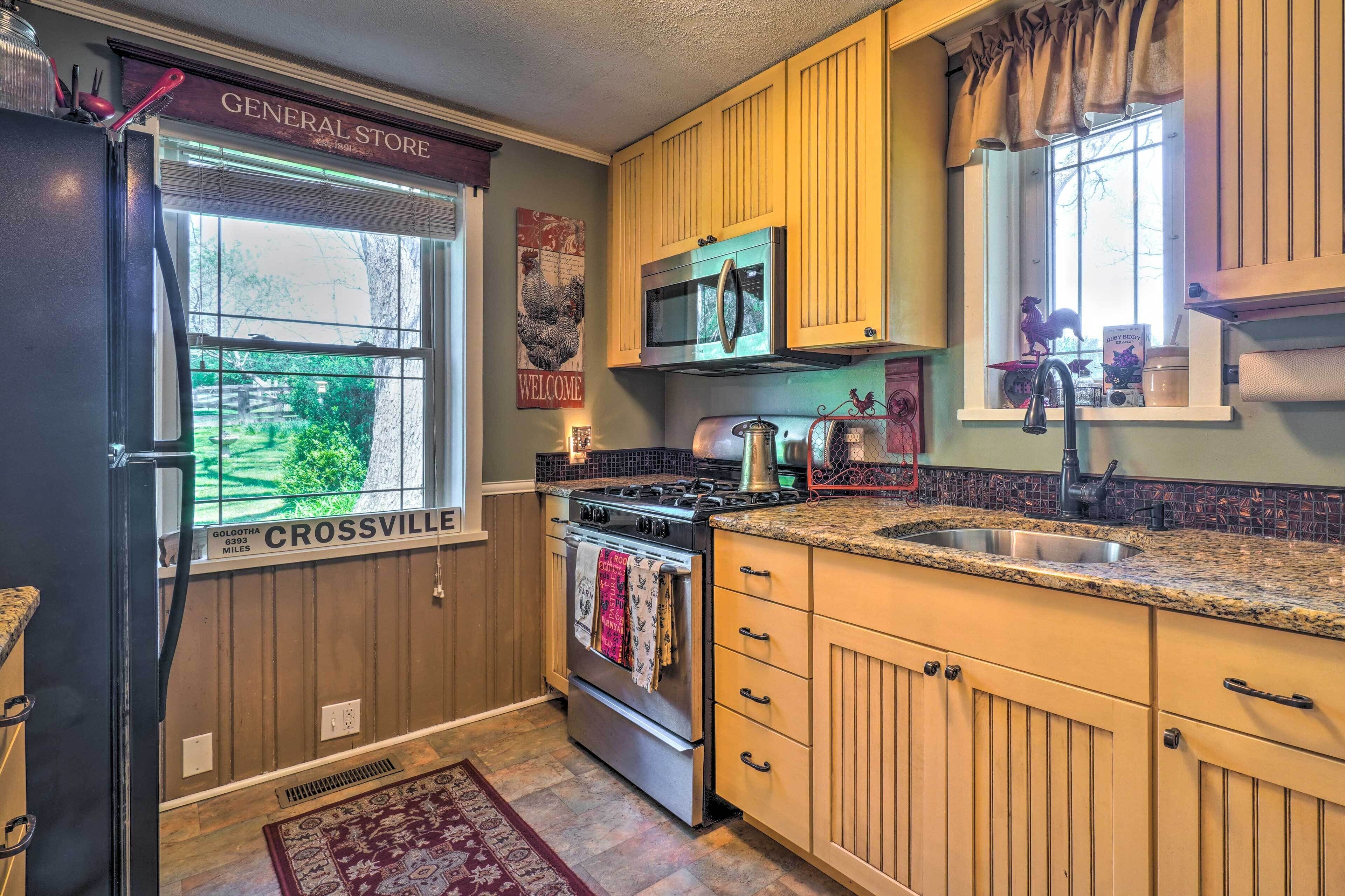 A kitchen with wooden cabinets, a stainless steel refrigerator, a microwave, and a stove.