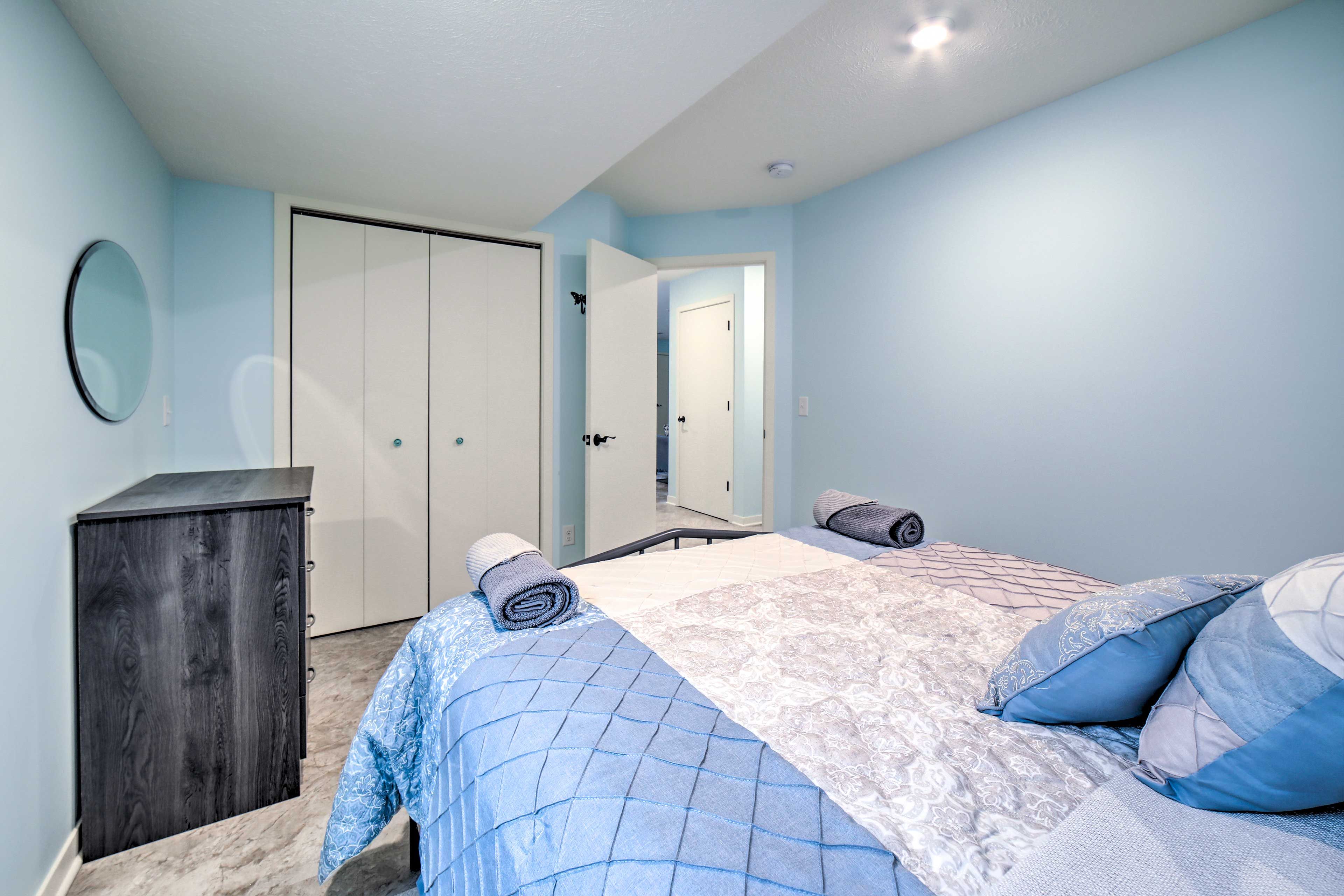Une chambre à coucher avec un lit, une armoire et un miroir.