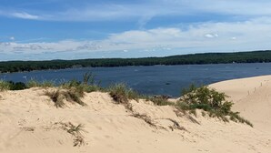 Un paisaje costero con dunas de arena y una extensión de agua.