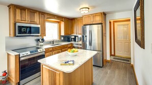 Una cucina moderna con mobili in legno, elettrodomestici in acciaio inossidabile e un'isola in marmo.