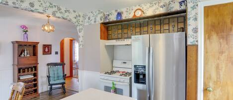 Eine Küche mit Kühlschrank, Herd und Holzschränken.