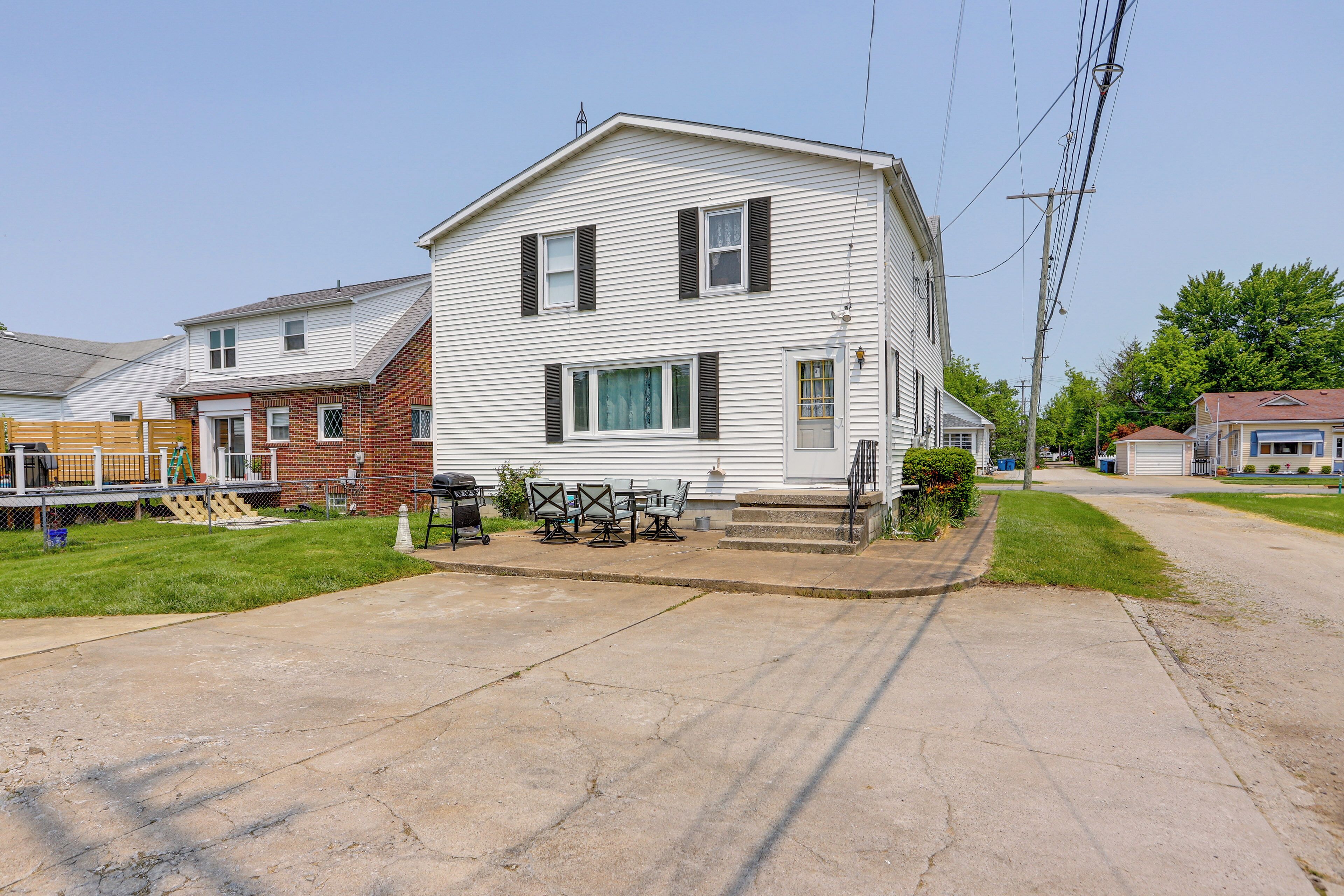 A two-story house with a front porch, a small attached garage, and a well-maintained lawn.
