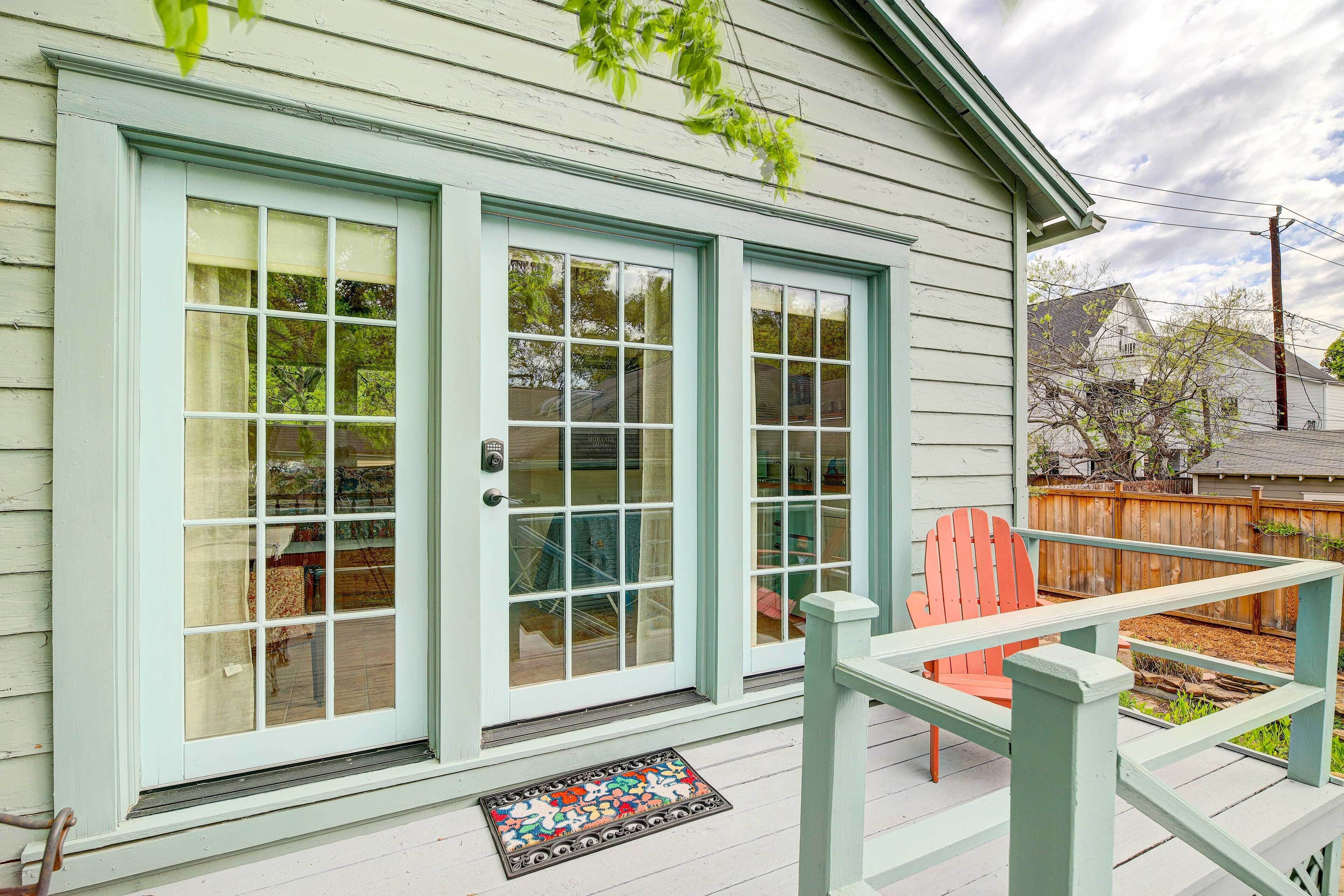 A house with a porch, a wooden fence, and a red chair.