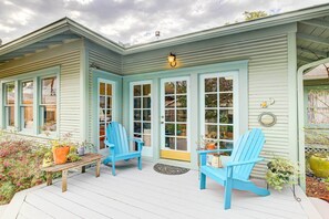 A porch with two blue Adirondack chairs, a wooden bench, and potted plants. - Pet-friendly Garden Studio in Woodland Heights! (Houston)