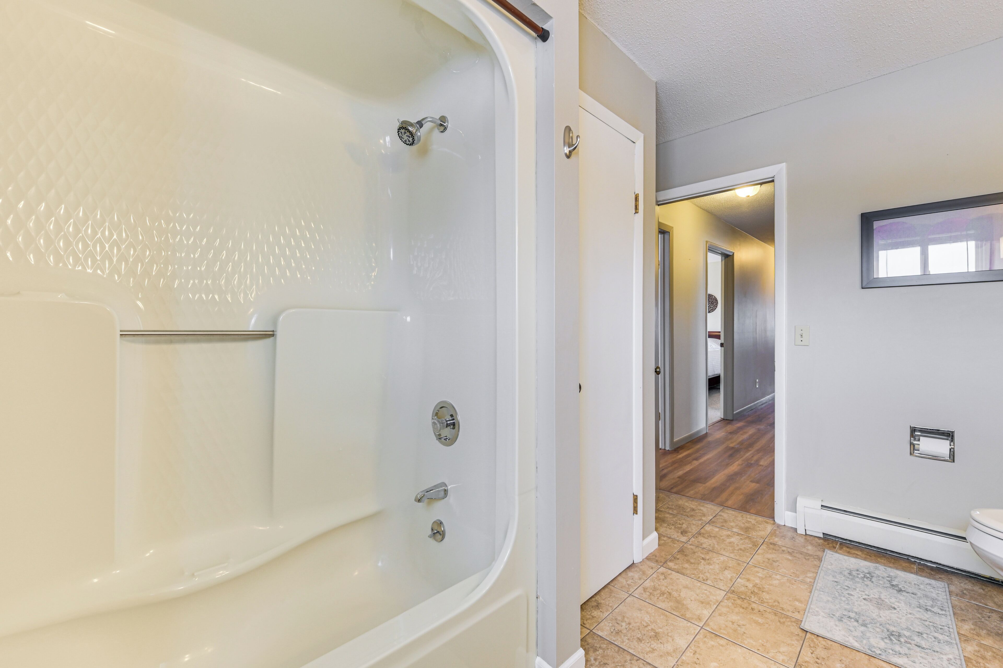 Ein modernes Badezimmer mit freistehender Badewanne, Toilette und Duschbereich.