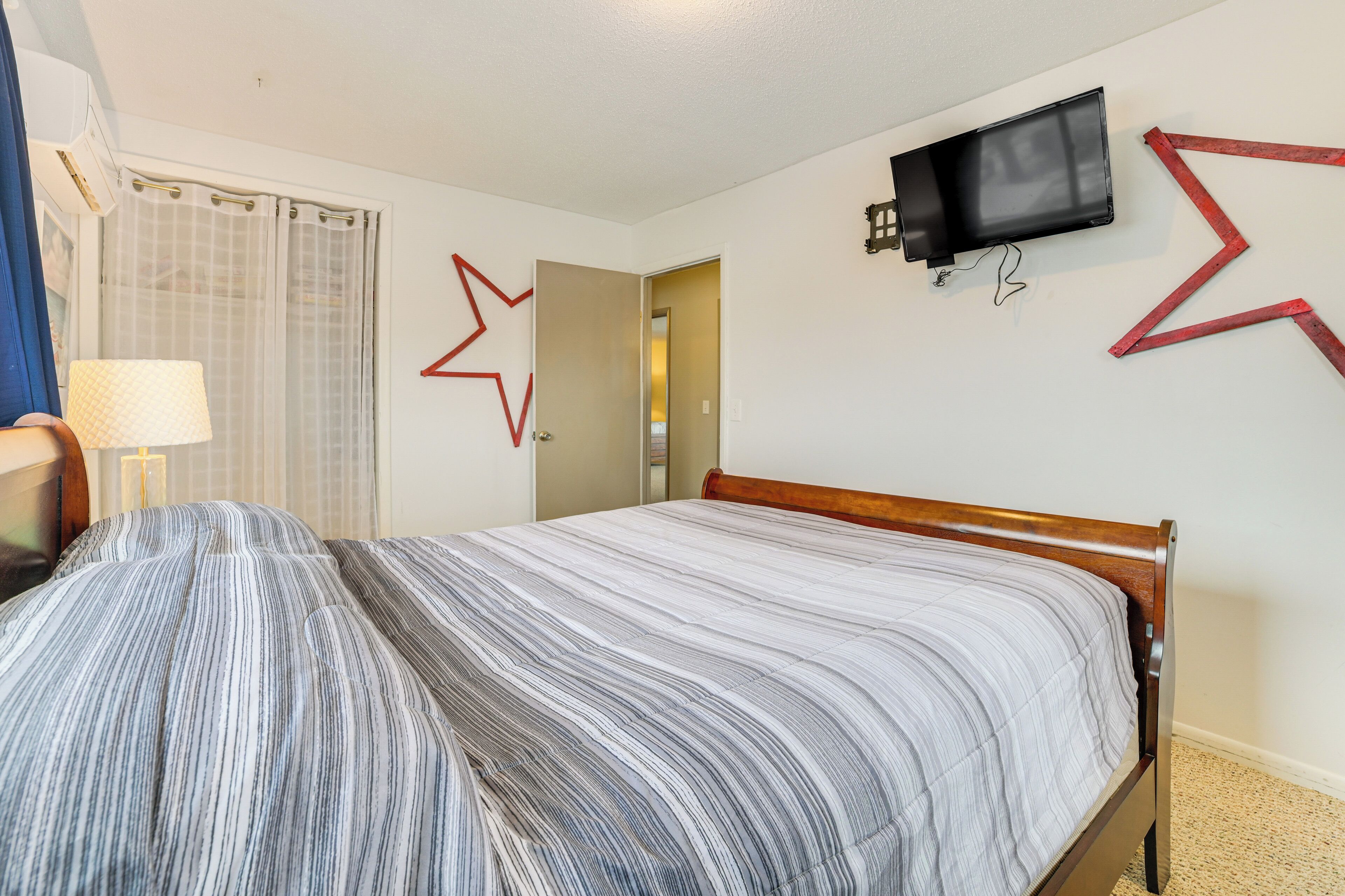 A hotel room with a bed, a TV mounted on the wall, and a star-shaped decoration.