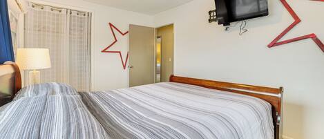 A hotel room with a bed, a TV mounted on the wall, and a star-shaped decoration.