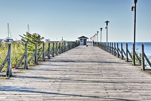 A wooden pier extending into the water with a small shelter at the end. - Peaceful Downtown East Tawas Lakefront Retreat (East Tawas)