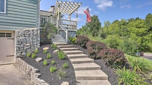 A house with a stone exterior, a porch with a pergola, and a flag. - Family-friendly Brookville Home w/ Hot Tub! (Brookville)