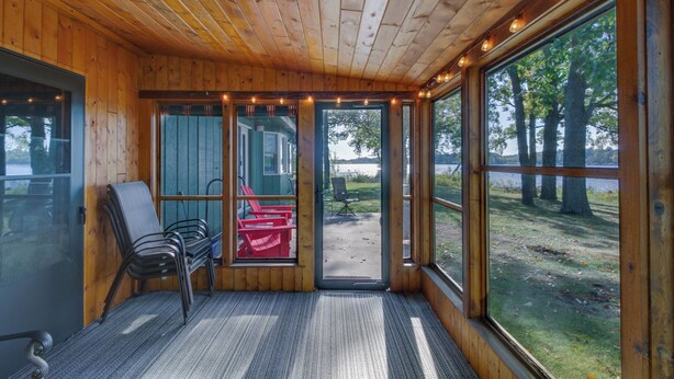 Una cabaña con interior de madera, ventanas amplias y vistas al exterior.