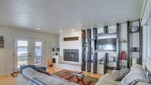Una sala de estar con chimenea, televisor y estantería.