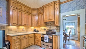 A kitchen with wooden cabinets, a stainless steel oven, and a granite countertop.