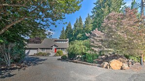 A two-story house with a gravel driveway, surrounded by trees and shrubs. - Lovely Snohomish Studio Near Boating & Hiking (Snohomish)