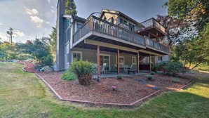 A two-story house with a covered patio, a stone retaining wall, and a landscaped garden. - Lovely Snohomish Studio Near Boating & Hiking (Snohomish)
