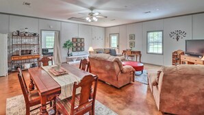 A spacious living room with a large sofa, a dining table, and a kitchen area with a microwave and cabinets. - Heavenly Heber Springs Hideaway: Fish & Hike! (Heber Springs)