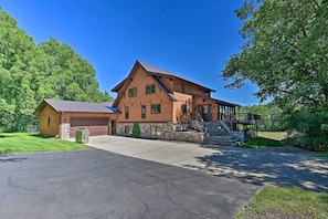 A large, two-story house with a stone foundation, a garage, and a covered porch. - Lodge w/ Indoor Pool, Along Devil's Lake Park (Merrimac)